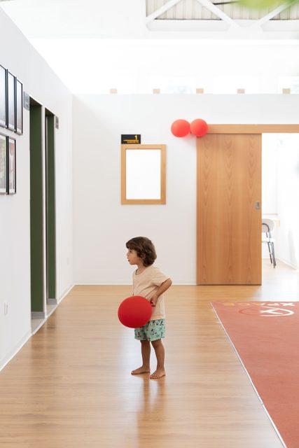 Criança com uma bola vermelha na sala de treino