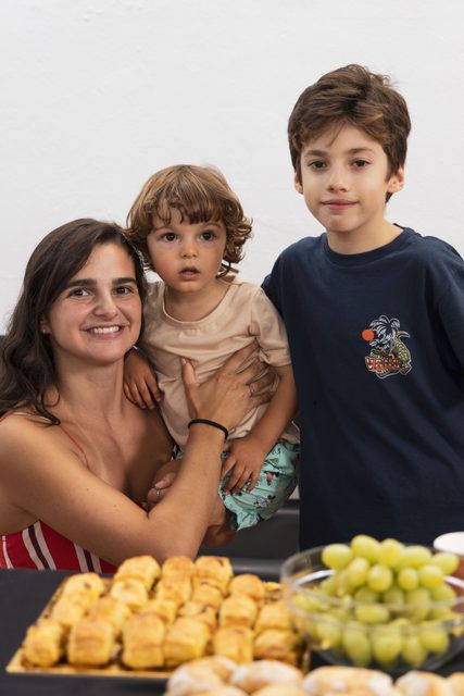 Convidada e crianças junto à mesa do lanche